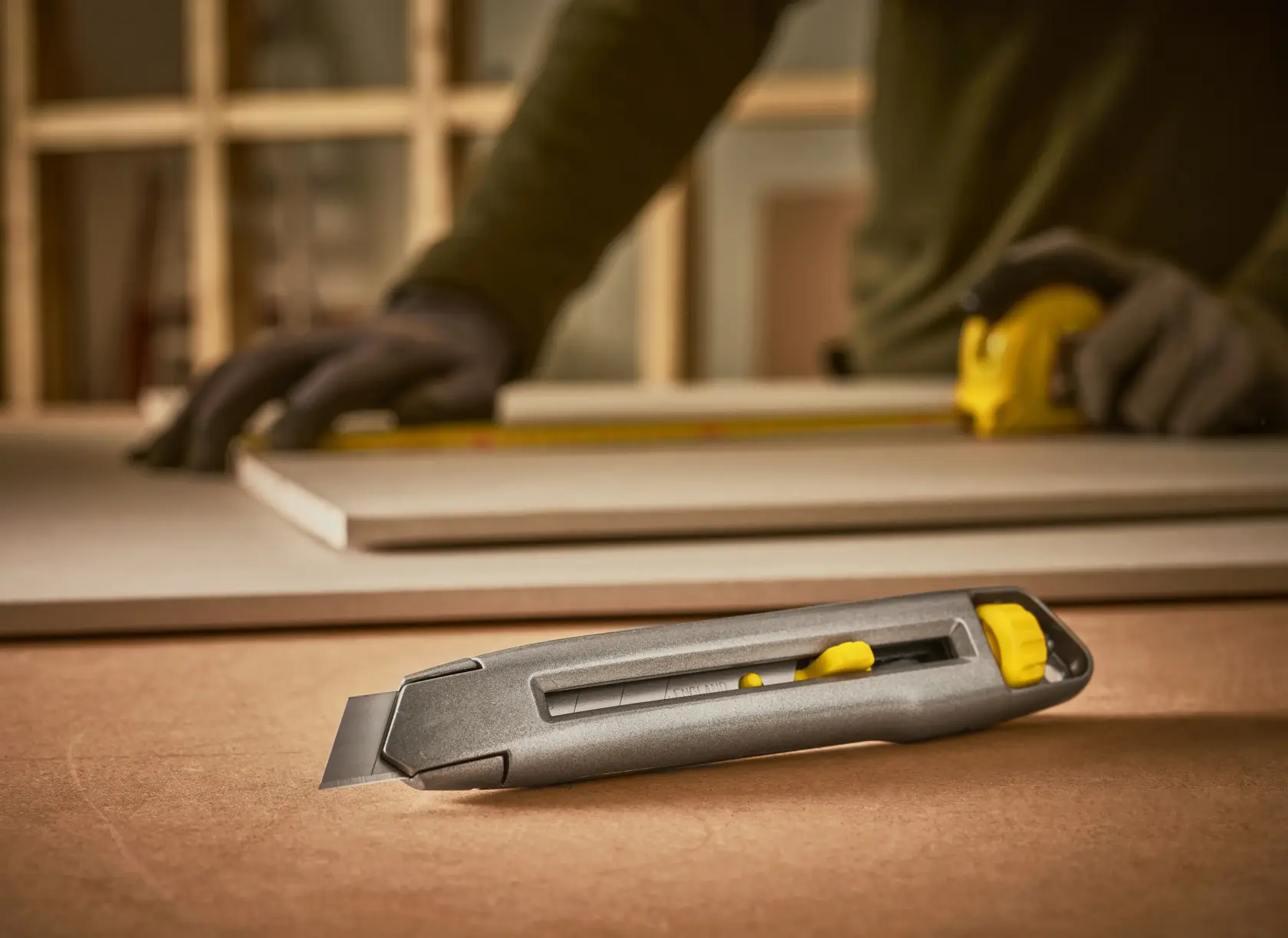 STANLEY 0-10-018 utility knife with retractable blade on worktable, construction scene.