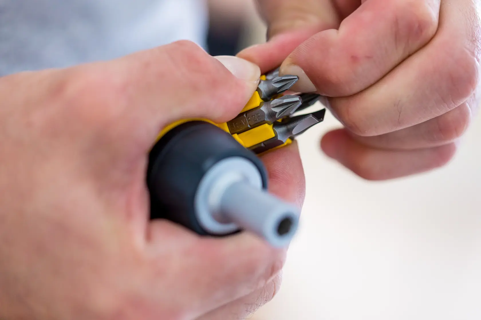 Photo of STANLEY 0-66-358 screwdriver with interchangeable bits held in hand, close-up view.