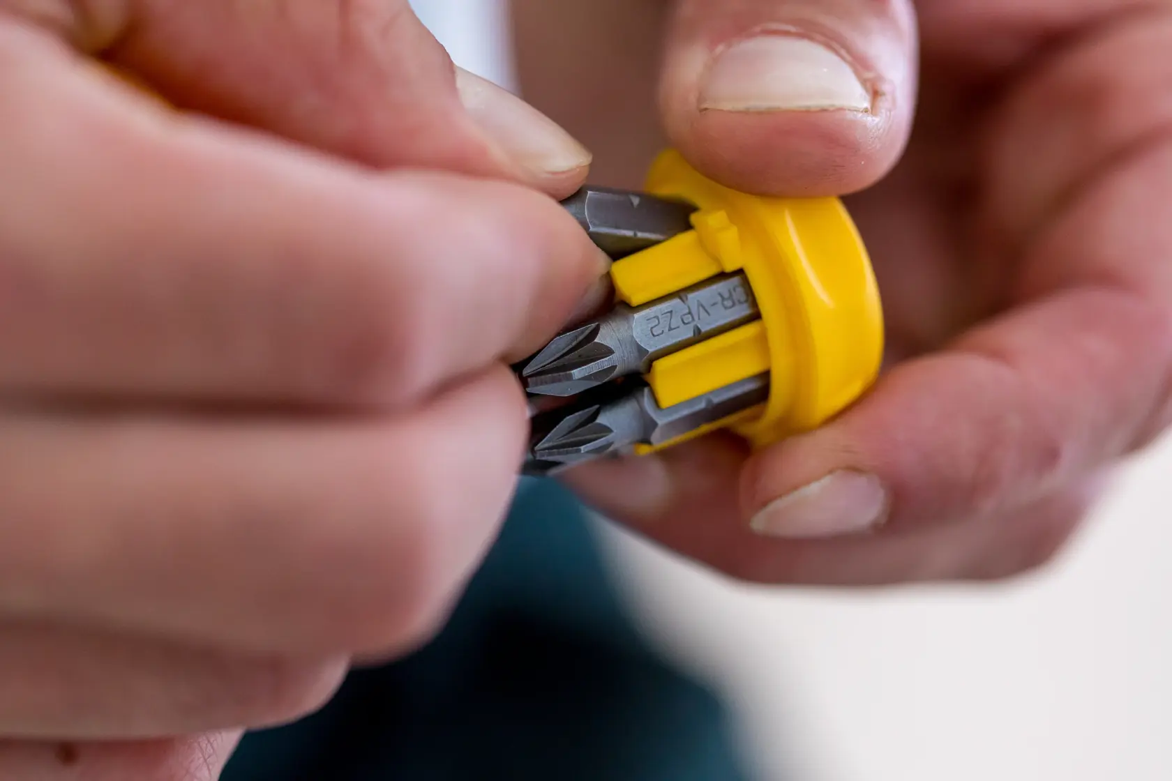 Stanley 0-66-358 screwdriver bits in yellow holder, close-up view of hand selecting bit.