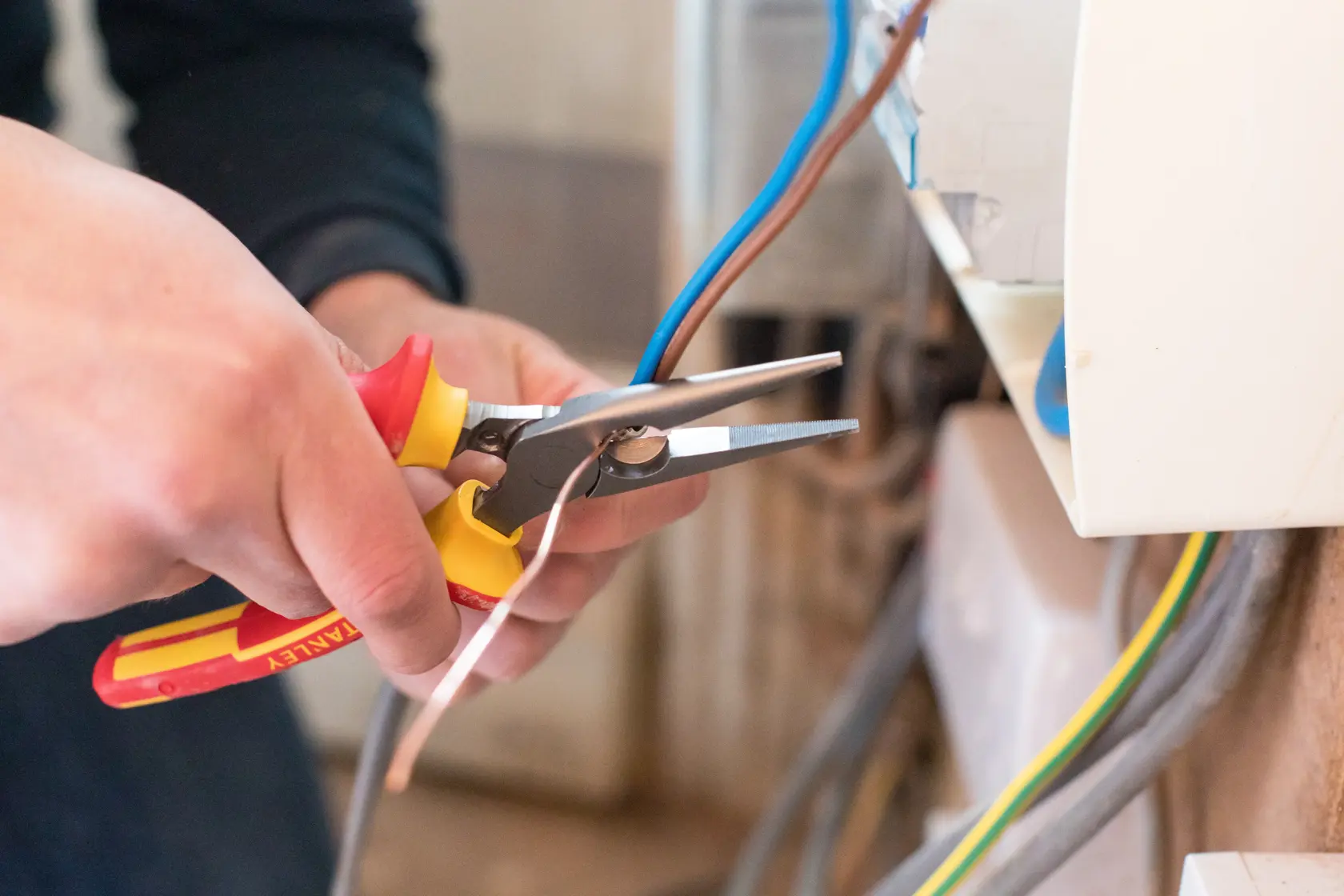 Photo of STANLEY 0-84-006 insulated pliers being used to work on electrical wiring.