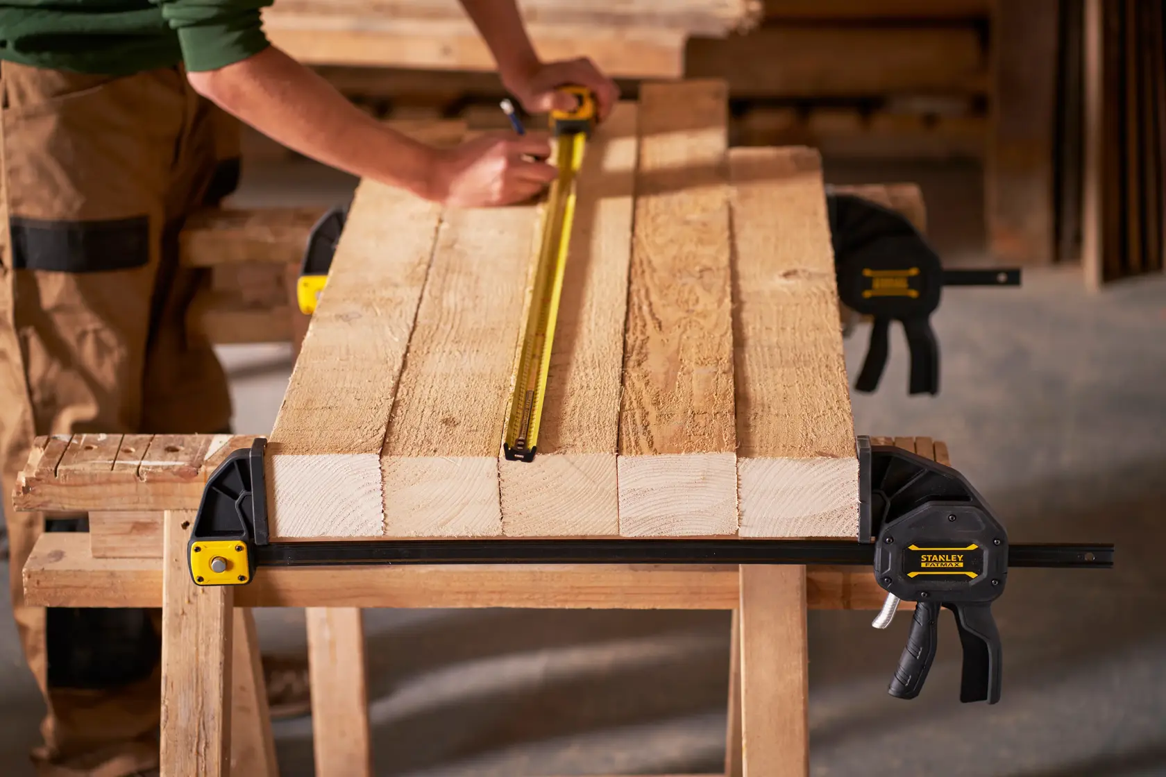 STANLEY FMHT0-83240 bar clamp securing wood, side angle, in workshop setting.