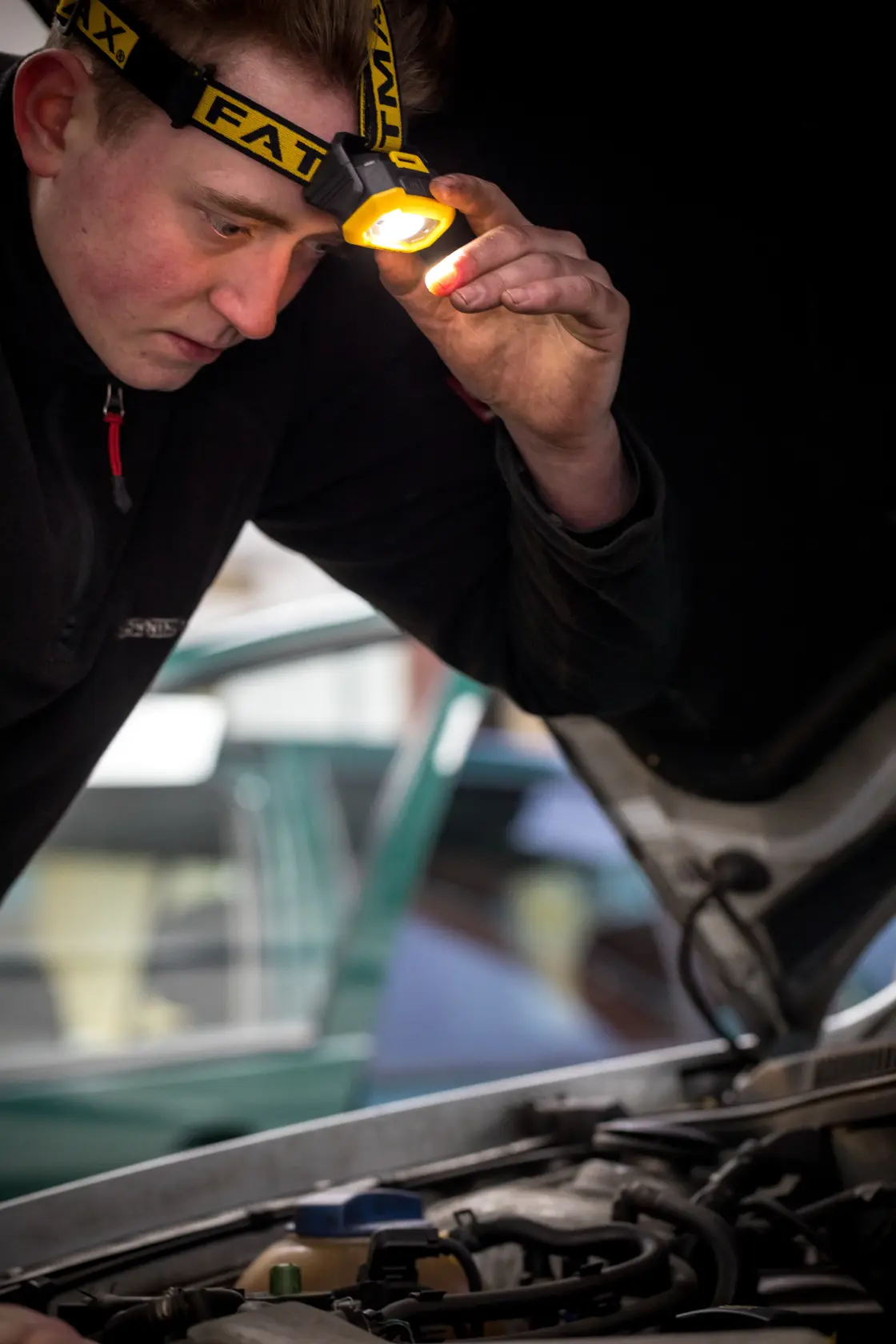 STANLEY FMHT81509-0 headlamp in use, illuminating engine compartment during automotive inspection.