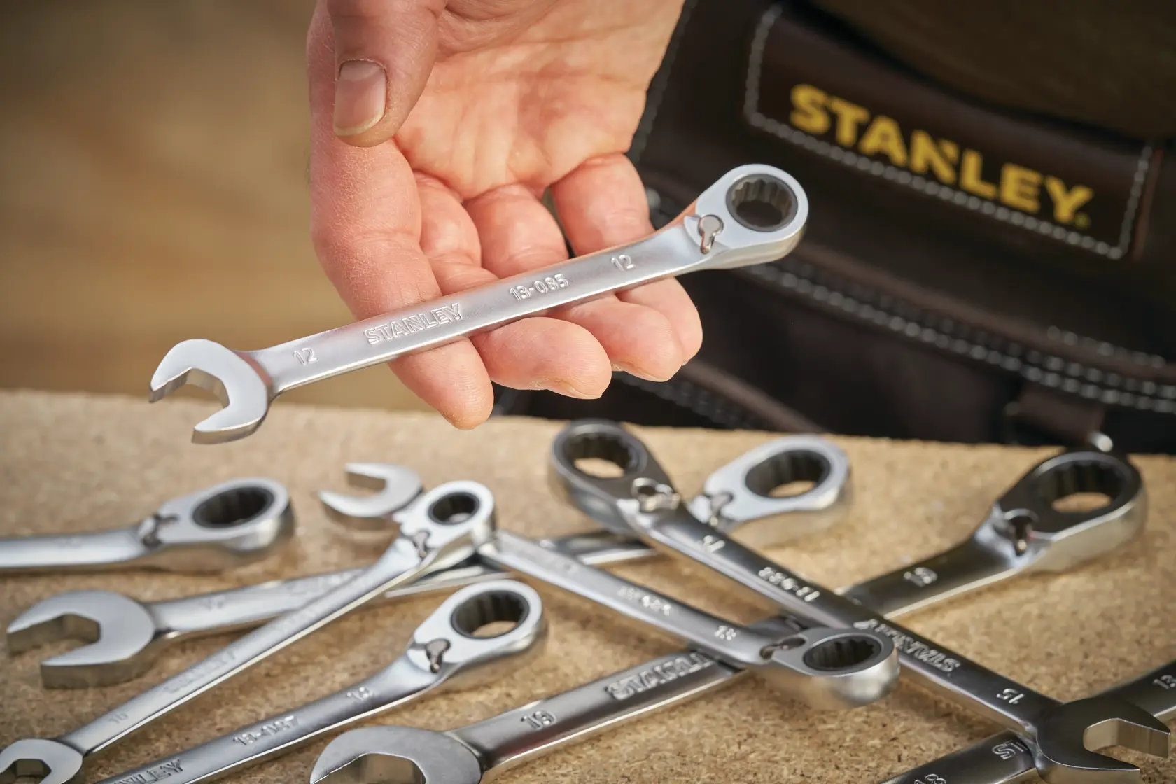 STANLEY FMMT13089-0 hand-held combination ratchet wrench set on workbench, close-up photo.