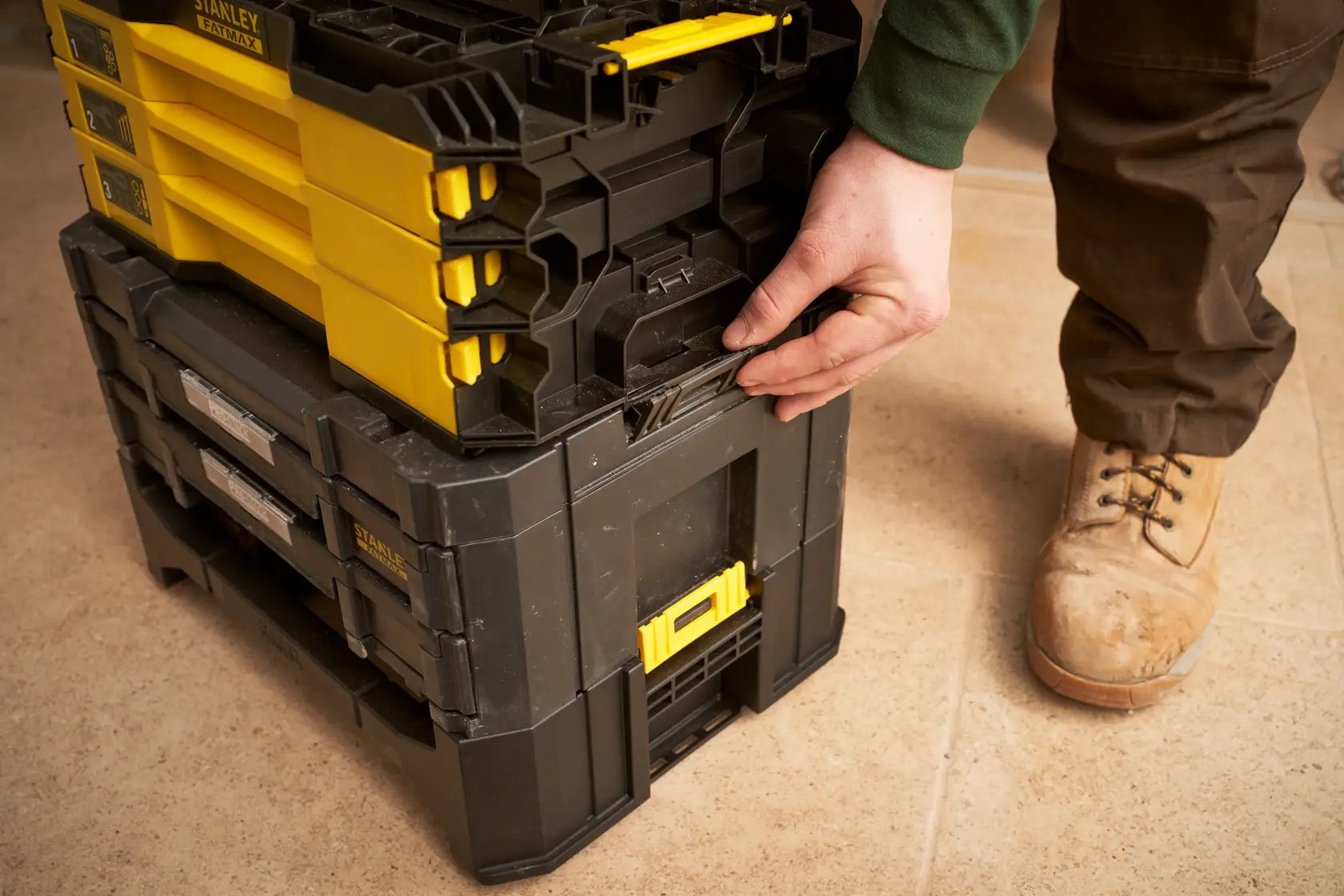 STANLEY FMMT98107-1 stackable toolboxes with yellow and black design, shown being latched together on tile floor.