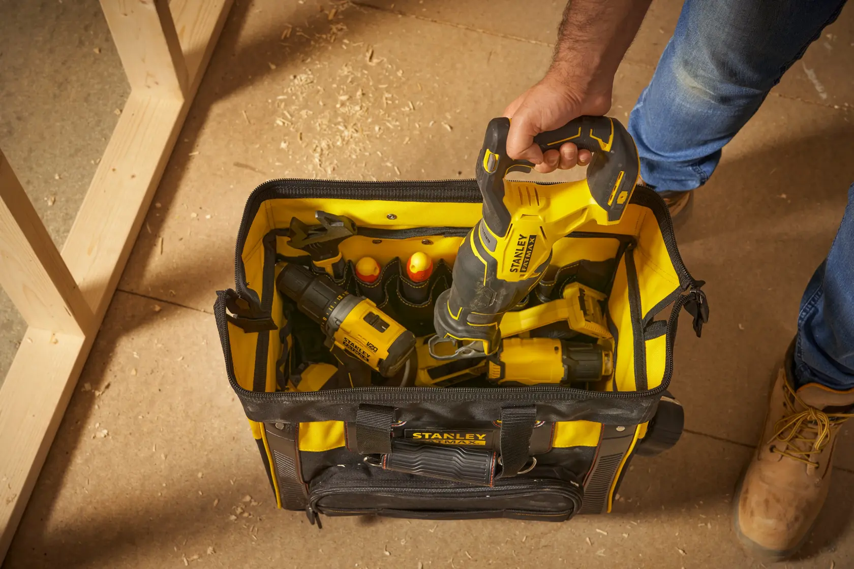 Photo of STANLEY FMST1-80148 tool bag filled with yellow-black power tools, viewed from above on a workshop floor.