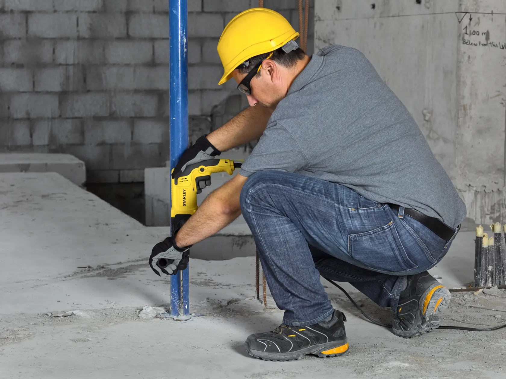 Stanley SHR263K-BR rotary hammer in use during floor installation, worker wearing safety gear.
