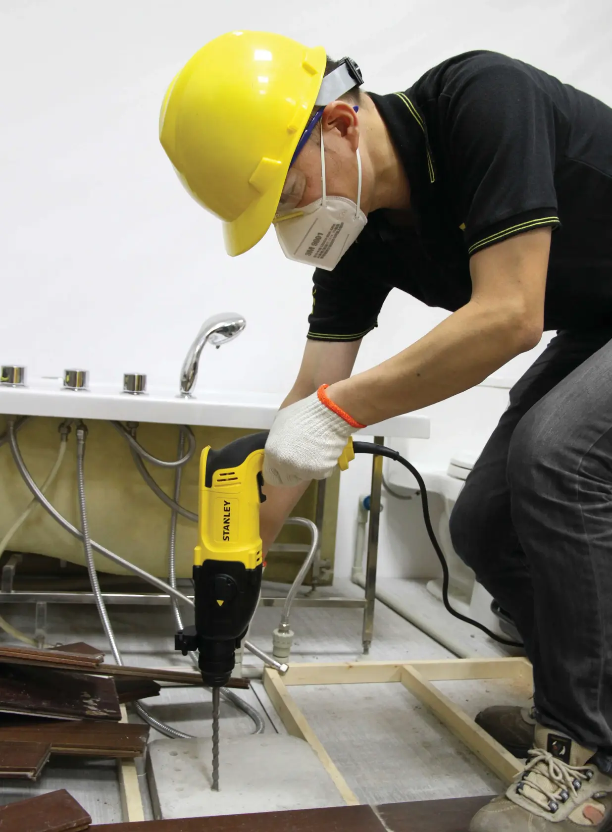 STANLEY SHR263K-BR rotary hammer used to drill floor near sink in construction setting.