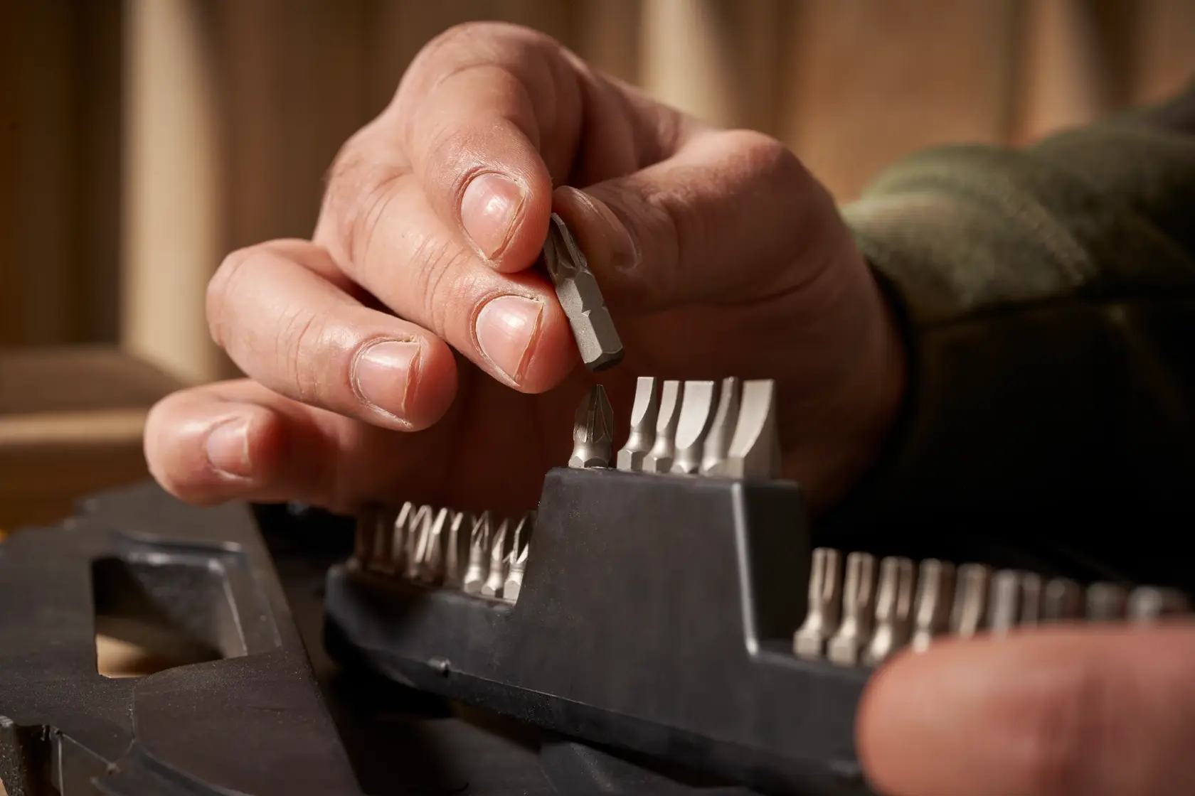STANLEY STA7184 screwdriver bit set photography, close-up of hand selecting a silver bit from black holder.