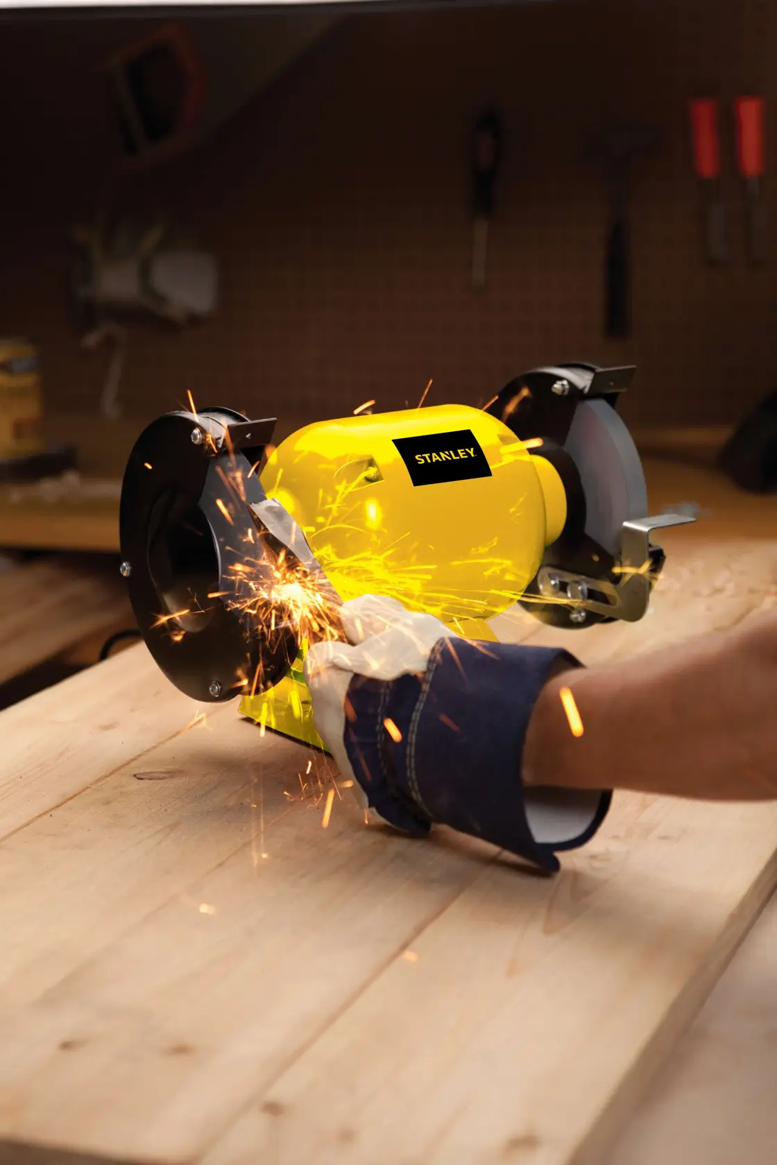 Stanley STGB3715 bench grinder in use with sparks flying, workshop setting, photography of power tool.