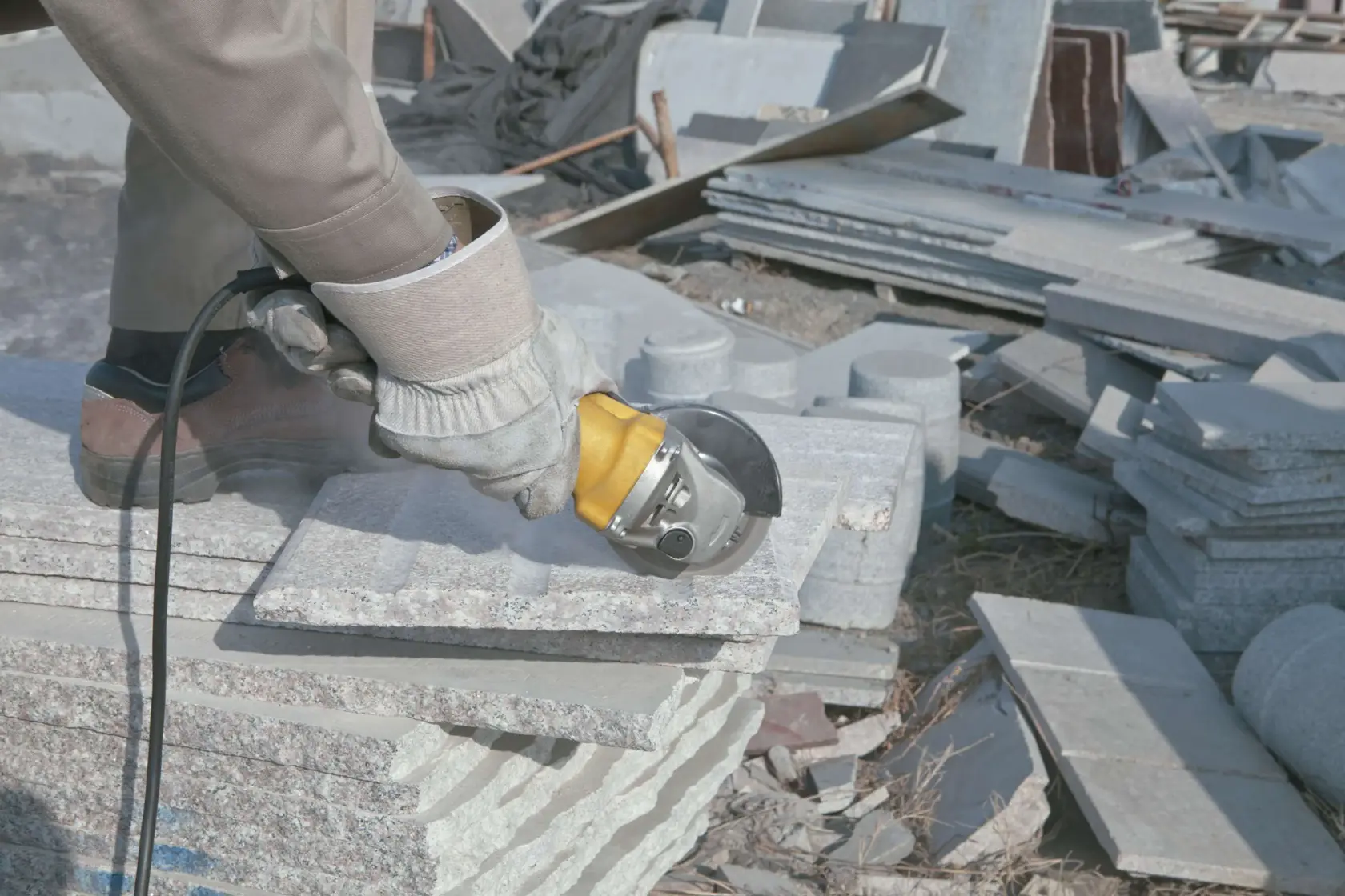Stanley STGS9125 angle grinder used on stone slab outdoors, close-up showing tool in action.