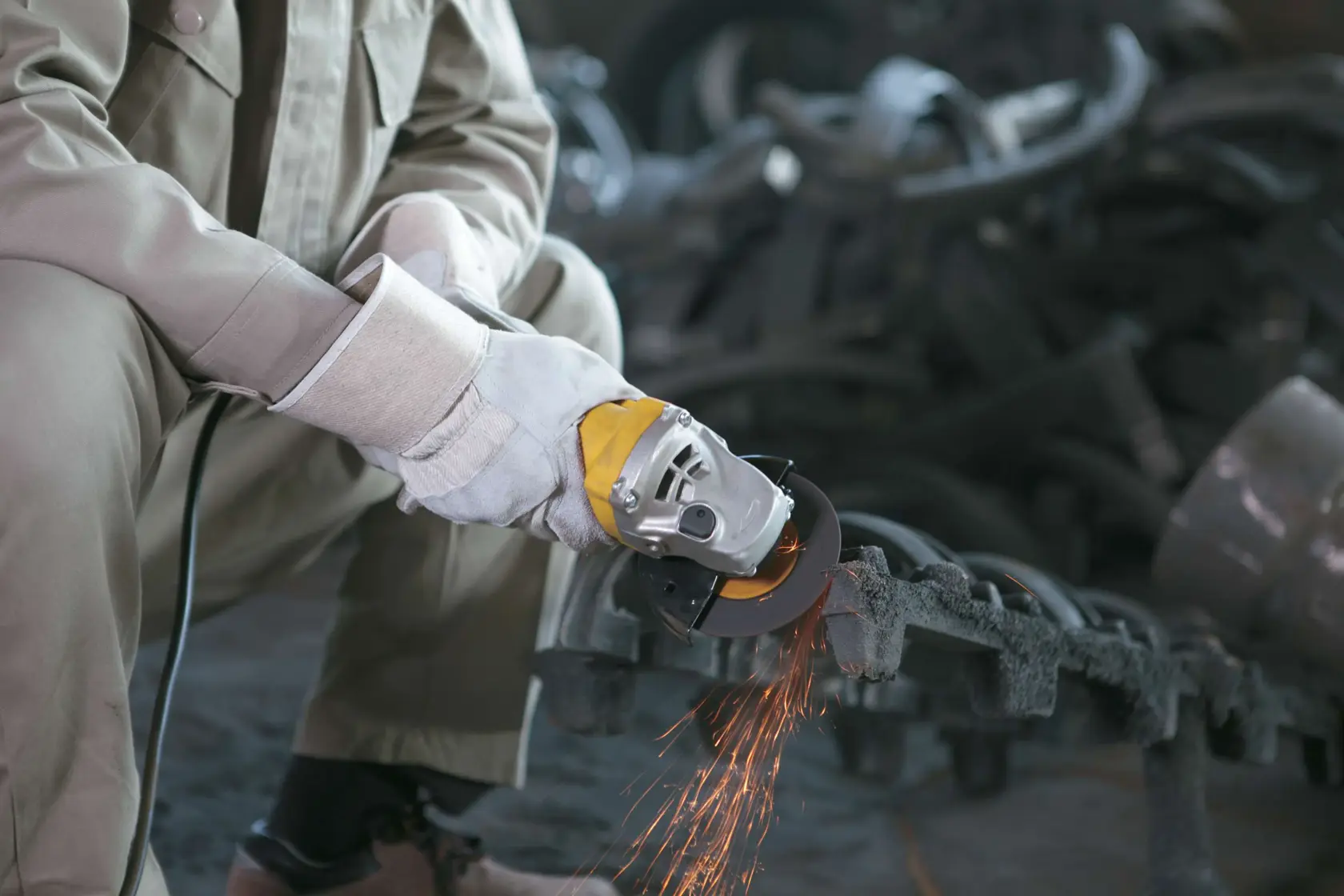 Stanley STGS9100-9125 angle grinder in use by worker, producing sparks, industrial setting.