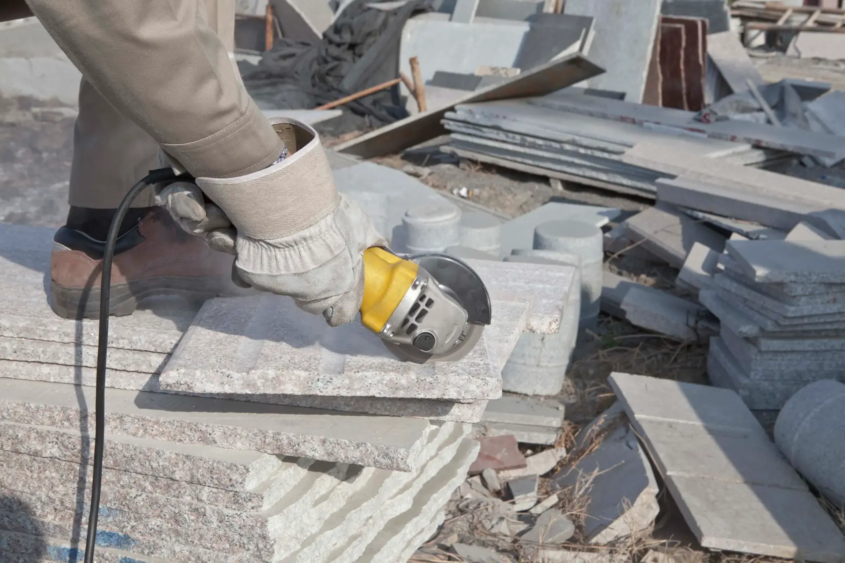 Stanley STGT8100 angle grinder used to cut stone slab outdoors, close-up of tool in action.