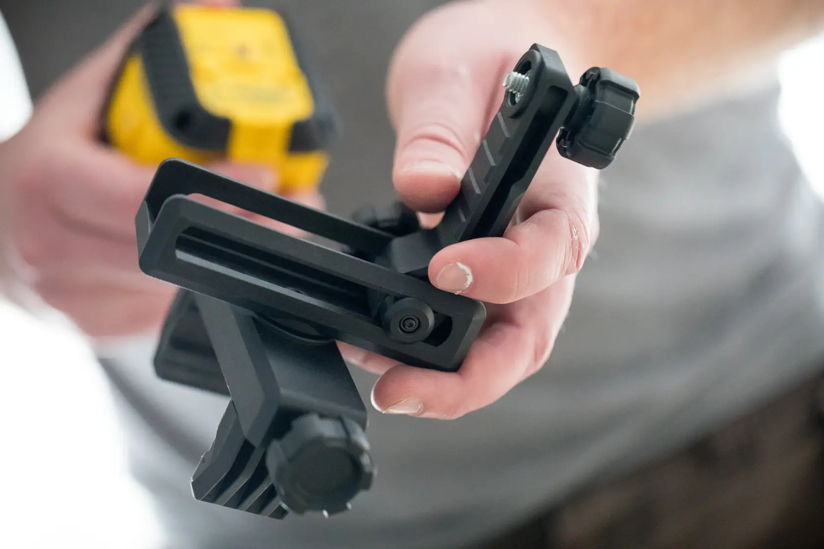 Photo of STANLEY STHT77498-1 photography accessory mount held in hand, black with adjustment knob.