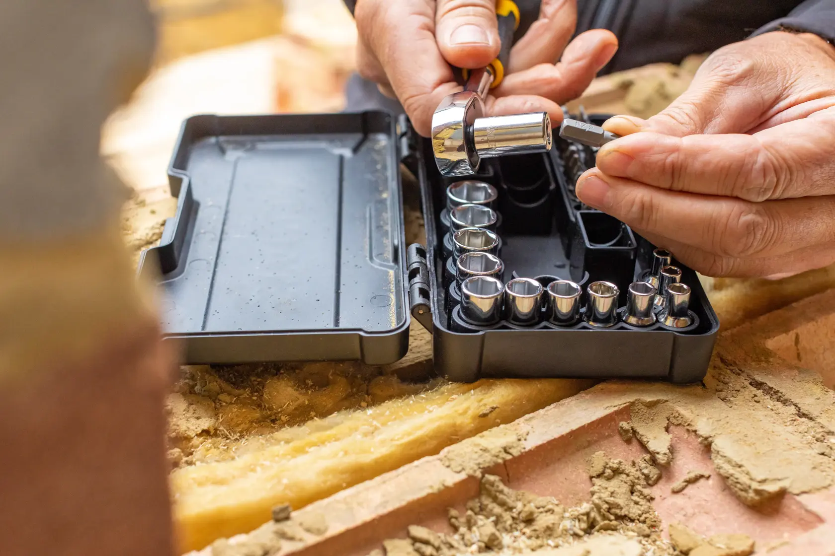 STANLEY STMT82672-0 socket set with ratchet in black case on a worksite, hands selecting a socket.
