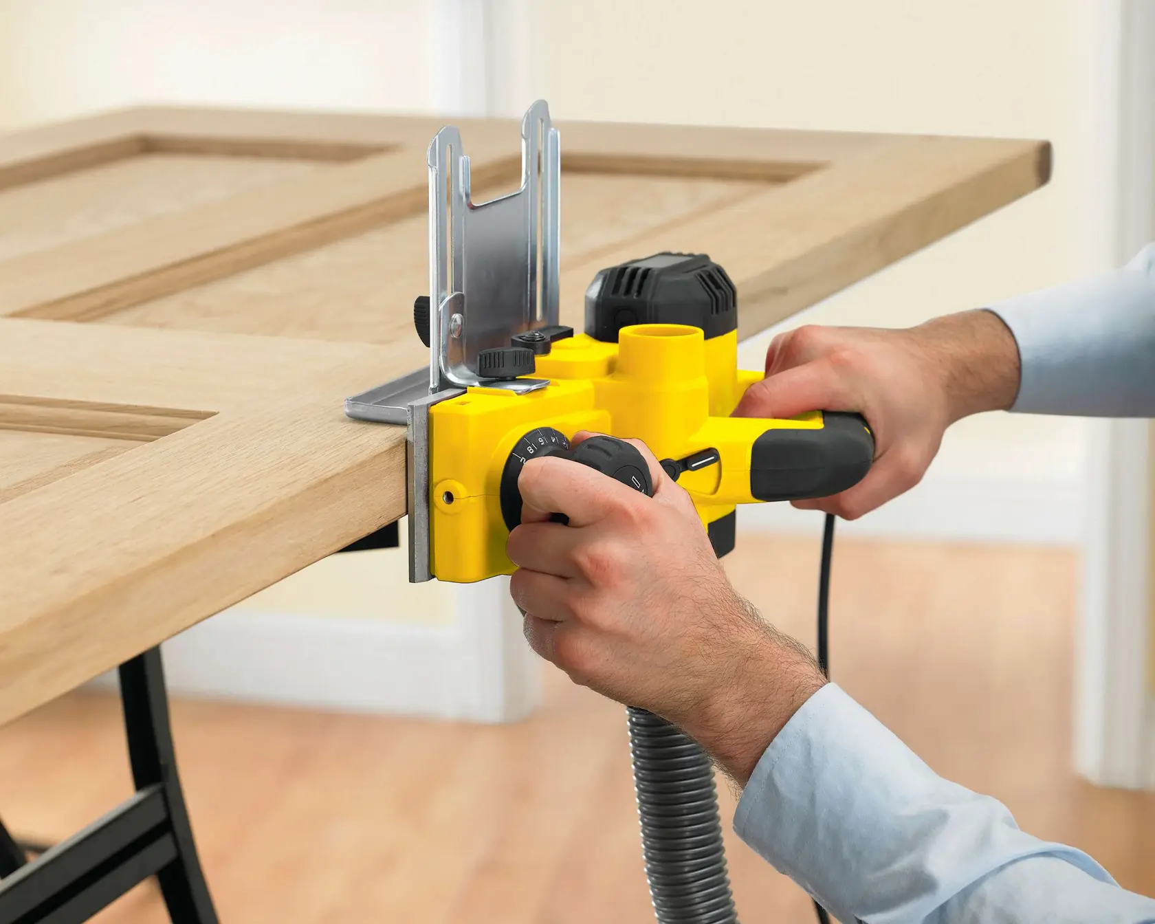 STANLEY STPP7502-B2 planer in use trimming a wooden door, close-up view, product photography.
