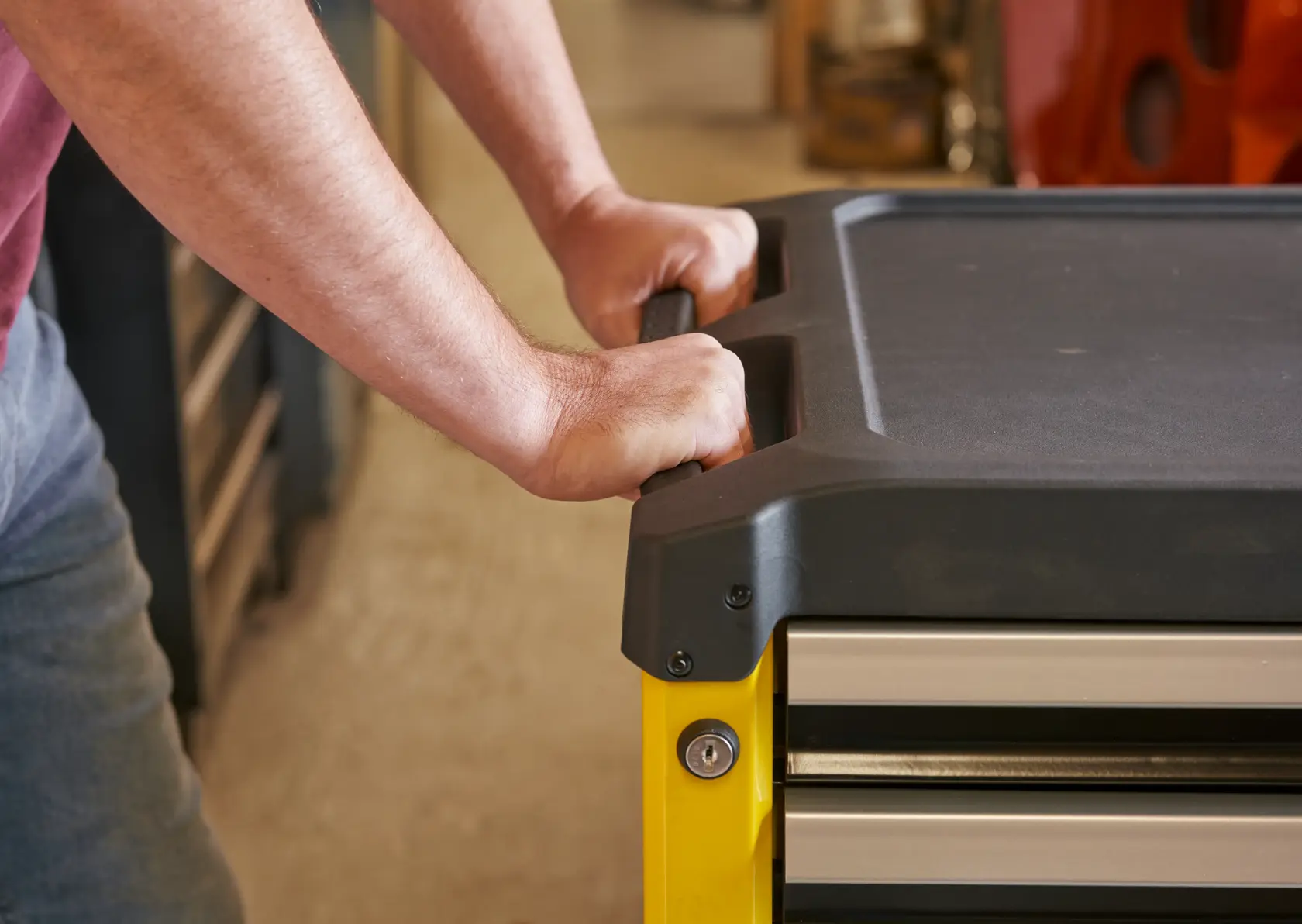 STANLEY STST74305-1 tool chest handle in use, close-up, black top, yellow frame, drawer visible.