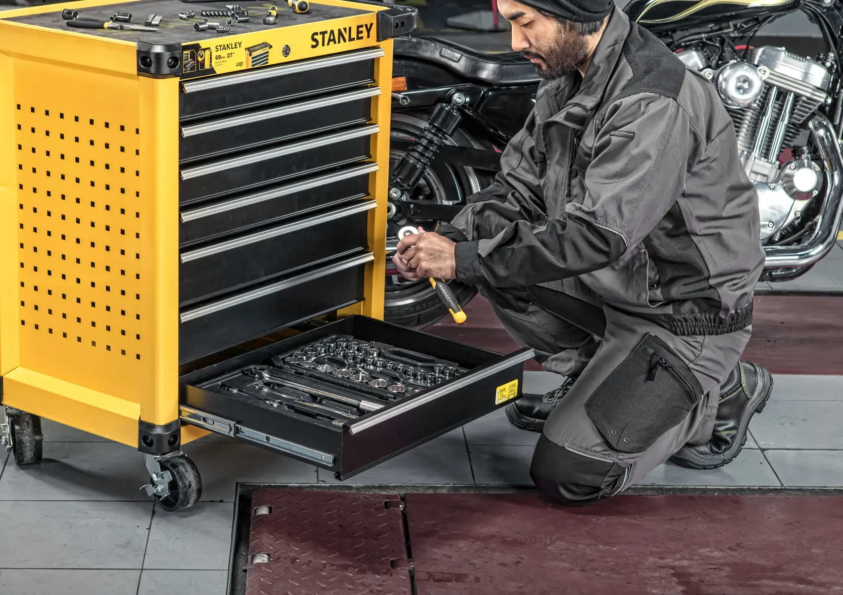 Stanley STST74306-8 yellow tool chest with open drawer of wrenches in garage workshop, side angle.