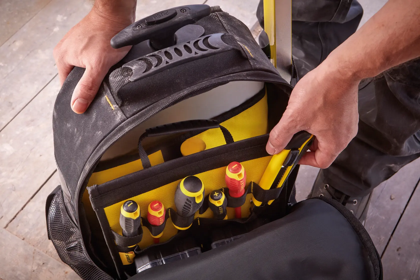 STANLEY STST83307-1 tool bag with multiple compartments and assorted hand tools, top view.