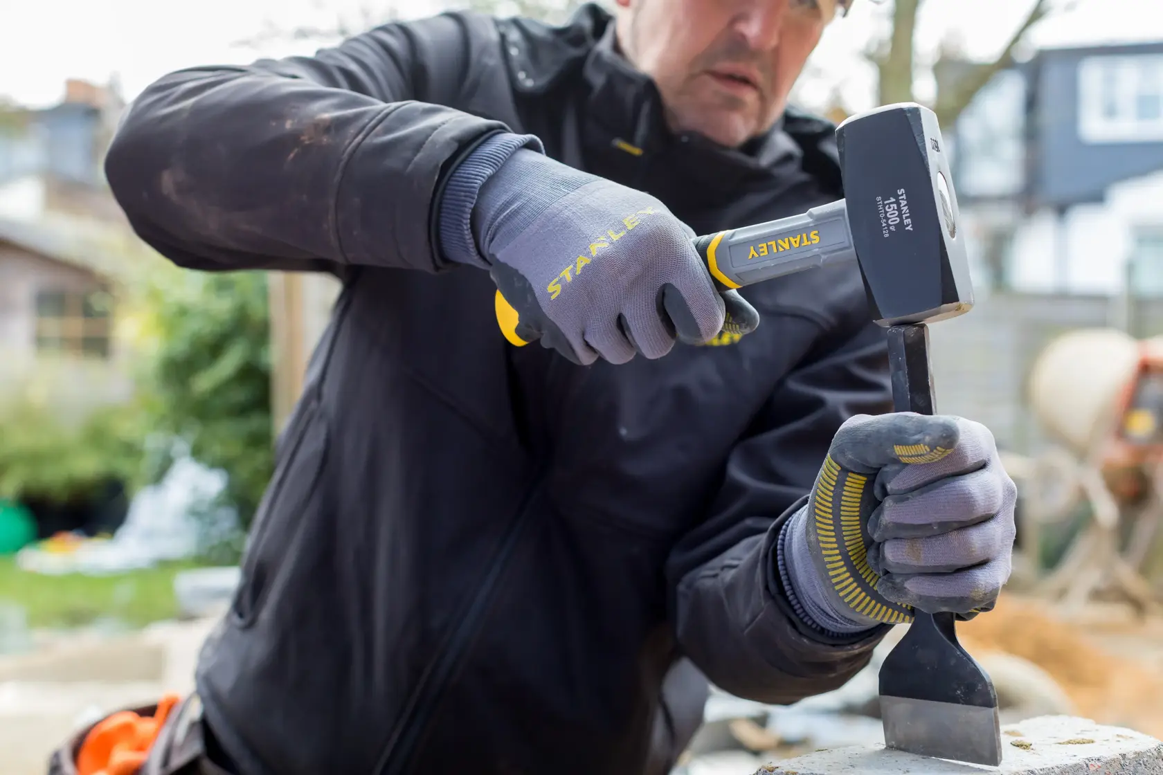 Photo of STANLEY STHT0-54128 sledgehammer in use by worker wearing gloves outdoors.